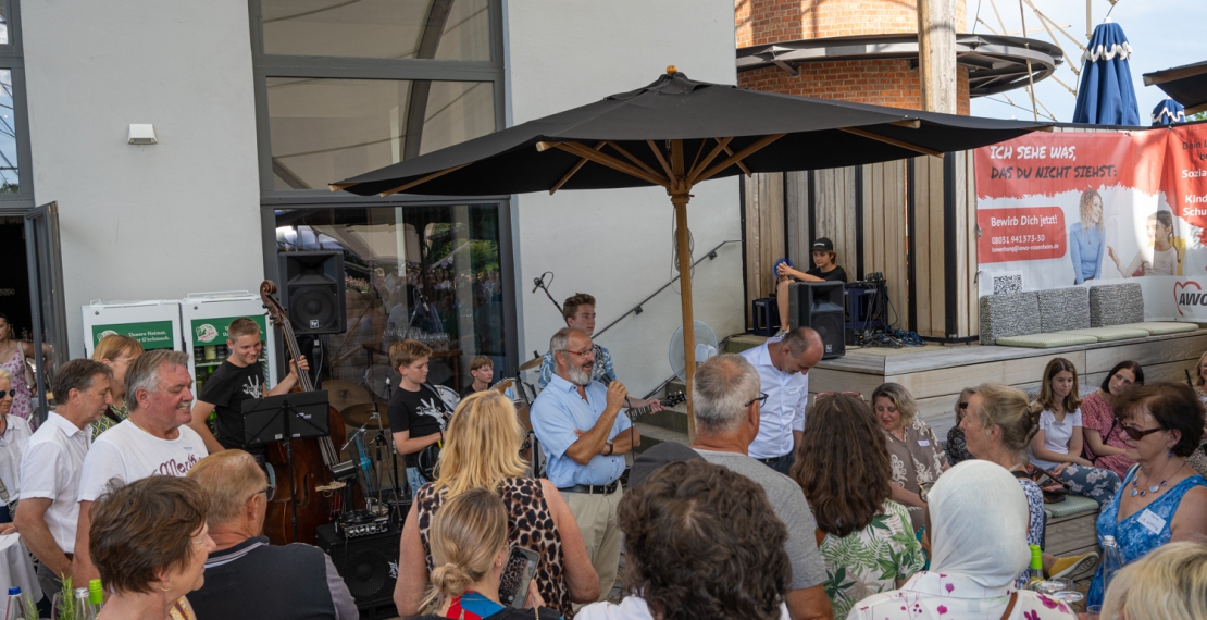 Die Rockwerkstatt der Stadtsing-und Musikschule Kolbermoor vor dem Kesselhaus im Rosengarten, davor Bürgermeister Kloo bei seiner Begrüßung